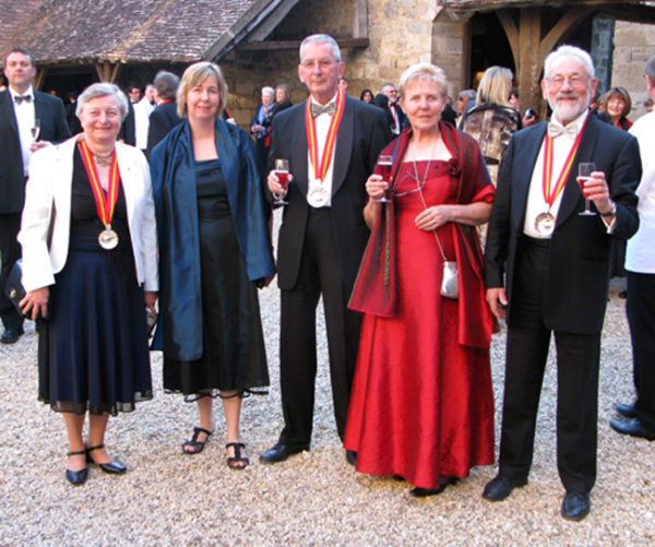 Damas e cavaleiros do Tastevin brindam no pátio central do Castelo Clos-de-Vougeot. 