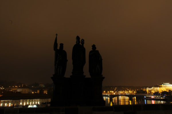 Santos sobre a Ponte Carlos se tornam fantasmagóricos imersos na neblina da noite em Praga.